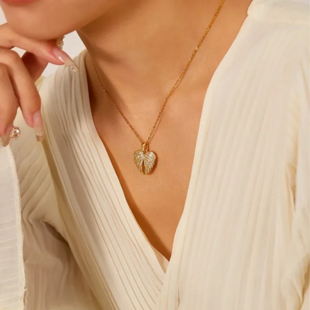Collana con ciondolo a forma di cuore racchiuso da ali brillanti